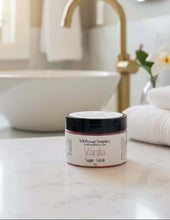 Load image into Gallery viewer, Vanilla Tallow Sugar Scrub in a stylish jar on a marble countertop with towels and a bowl in the background.