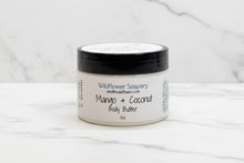 Load image into Gallery viewer, Jar of Wildflower Soapery Mango & Coconut Body Butter on a textured surface