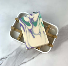 Load image into Gallery viewer, Spa Day Goat Milk Soap displayed on a bamboo soap dish, showcasing its colorful marbled design.
