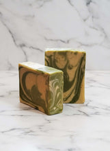 Load image into Gallery viewer, Two bars of handcrafted Spiced Citrus Buttermilk Soap with a marbled green and yellow design on a marble background.
