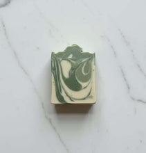 Load image into Gallery viewer, Spiced Citrus Buttermilk Soap with creamy green and white swirls on a marble background.