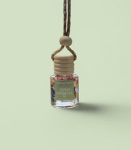 Load image into Gallery viewer, Herbal Indulgence Car Diffuser hanging from a rope, designed for soothing aromas in your vehicle.