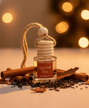 Load image into Gallery viewer, Spiced Tea Car Diffuser surrounded by cinnamon sticks and tea leaves, adding a warm festive scent to your car.