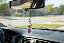Load image into Gallery viewer, Lavender hanging car diffuser hanging from rearview mirror, enhancing car ambiance with soothing fragrance.