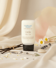 Load image into Gallery viewer, Vanilla Tallow Lotion bottle on soft fabric with floral accents and natural ingredients, perfect for nourishing skin.