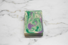 Load image into Gallery viewer, Tallow Goat Milk Soap with intricate green and purple swirls on a marble surface.