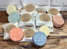 Load image into Gallery viewer, Multiple shampoo and conditioner bars packaged and unpackaged laying next to each other.