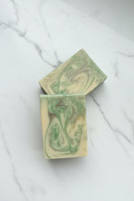 Load image into Gallery viewer, Two rectangular bars of handmade soap with a green and cream marble swirl pattern, displayed on a white marble surface.
