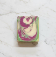 Load image into Gallery viewer, Agave Lime Goat Milk Soap with vibrant swirls of purple and green on a marble surface.
