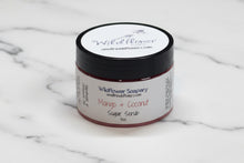 Load image into Gallery viewer, Jar of Wildflower Soapery Mango &amp; Coconut Sugar Scrub on a textured gray background
