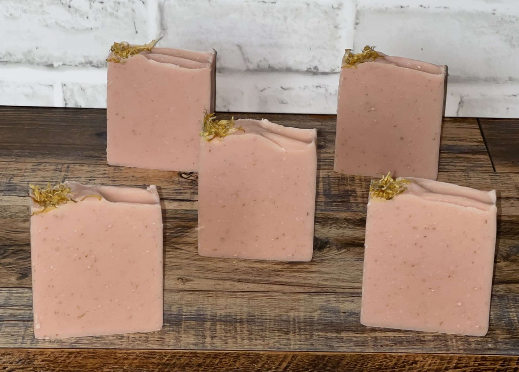 Light pink soap with yellow flower pedals on top staggered